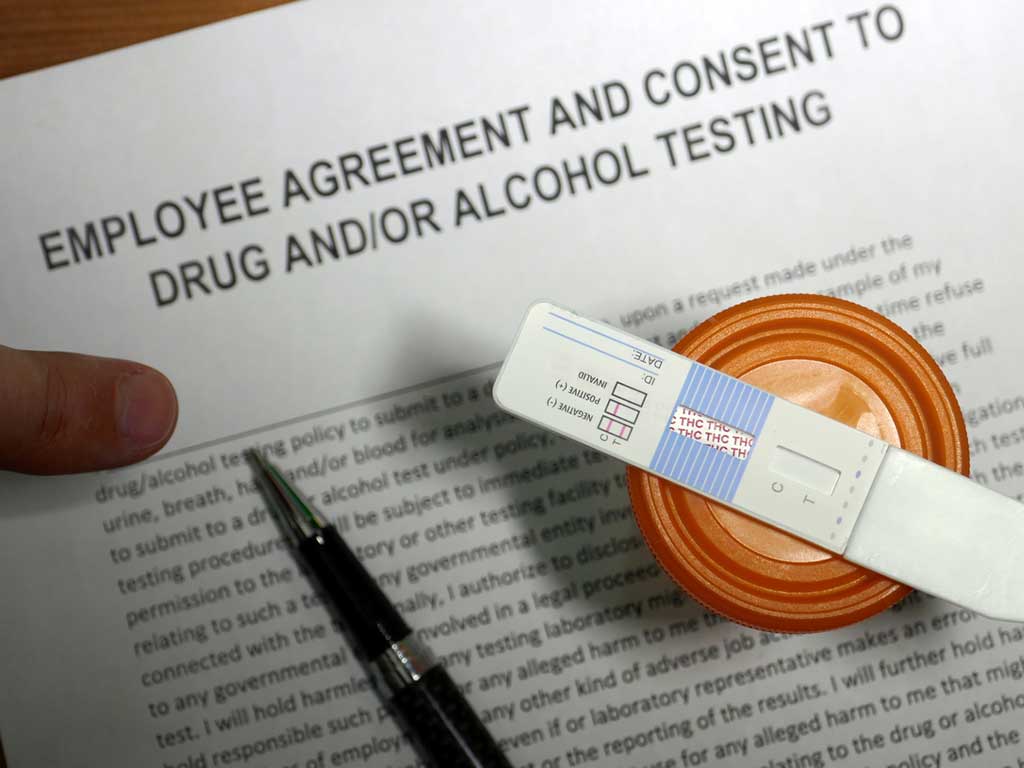 A pen and drug testing kit on top of a consent form