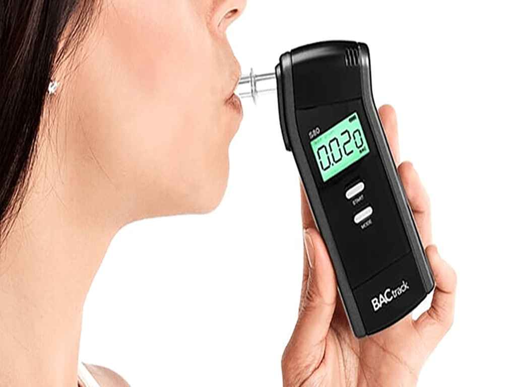 A woman using a professional-grade breathalyser