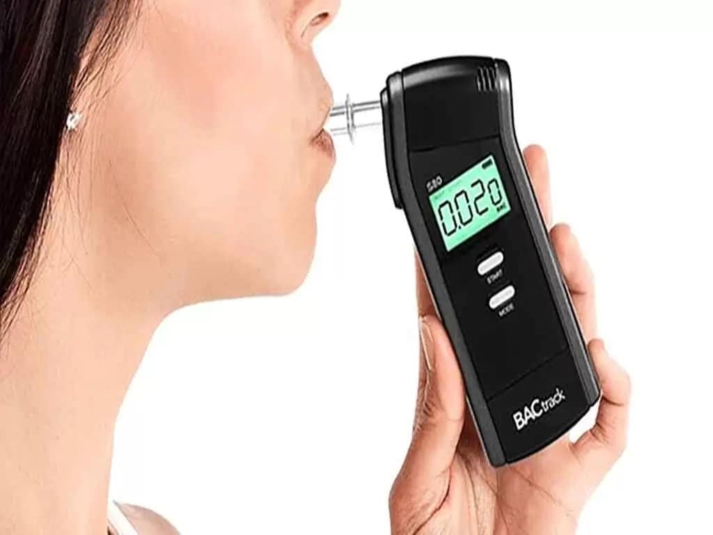 A woman blowing into the breathalyser