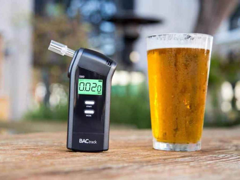 A breathalyser on the table with a drink