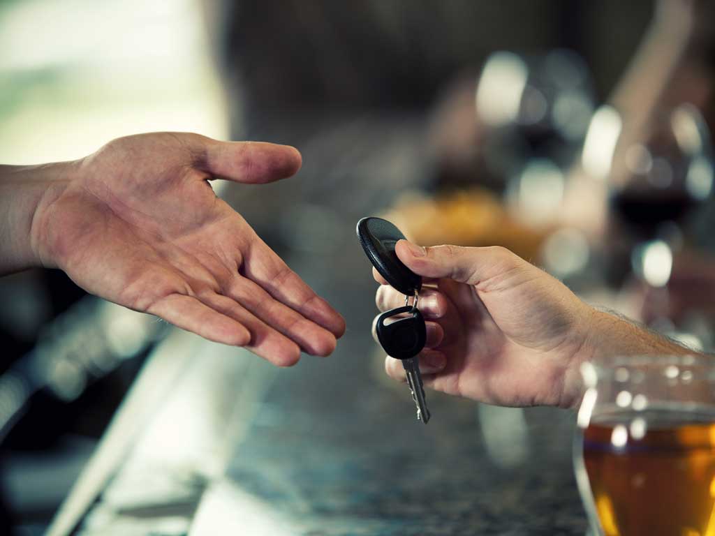 An individual giving their car keys to another person.