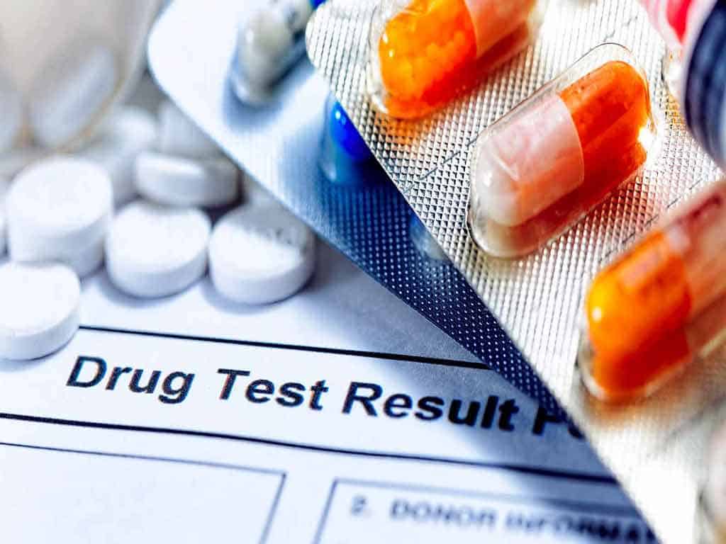 A drug test result form covered by pills