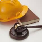 A hard hat, gavel, and book