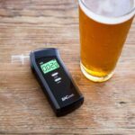 A breathalyser and a glass of beer on the table.