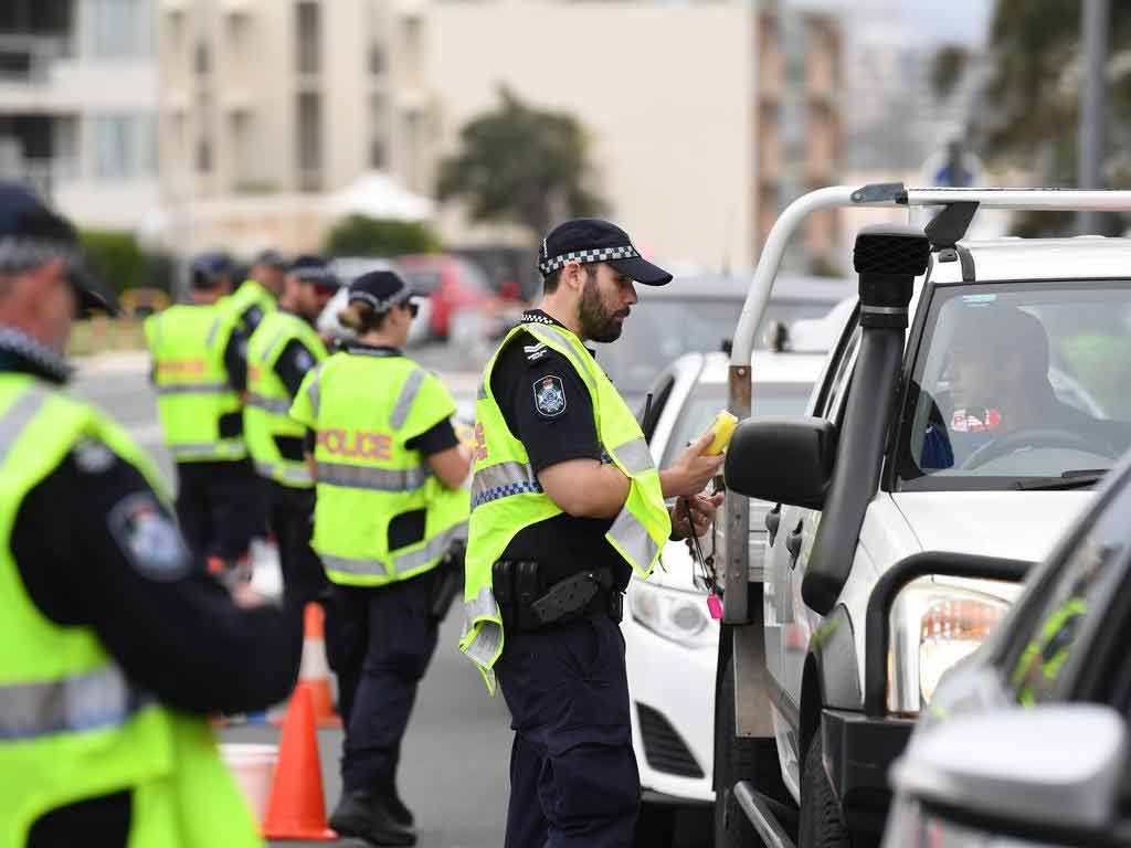 A police officer conducting a roadside breath test.