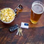 A keychain breathalyser, food and glass of beer on the table
