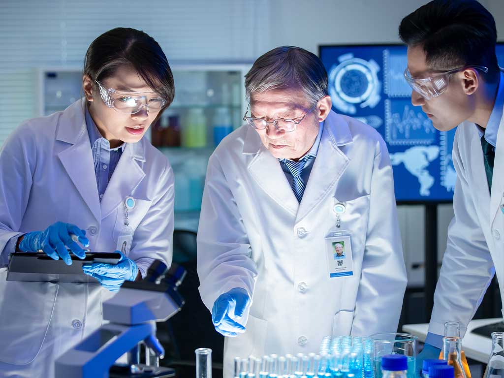 Three technicians discussing inside a lab