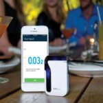 A breathalyser and smartphone on the table.
