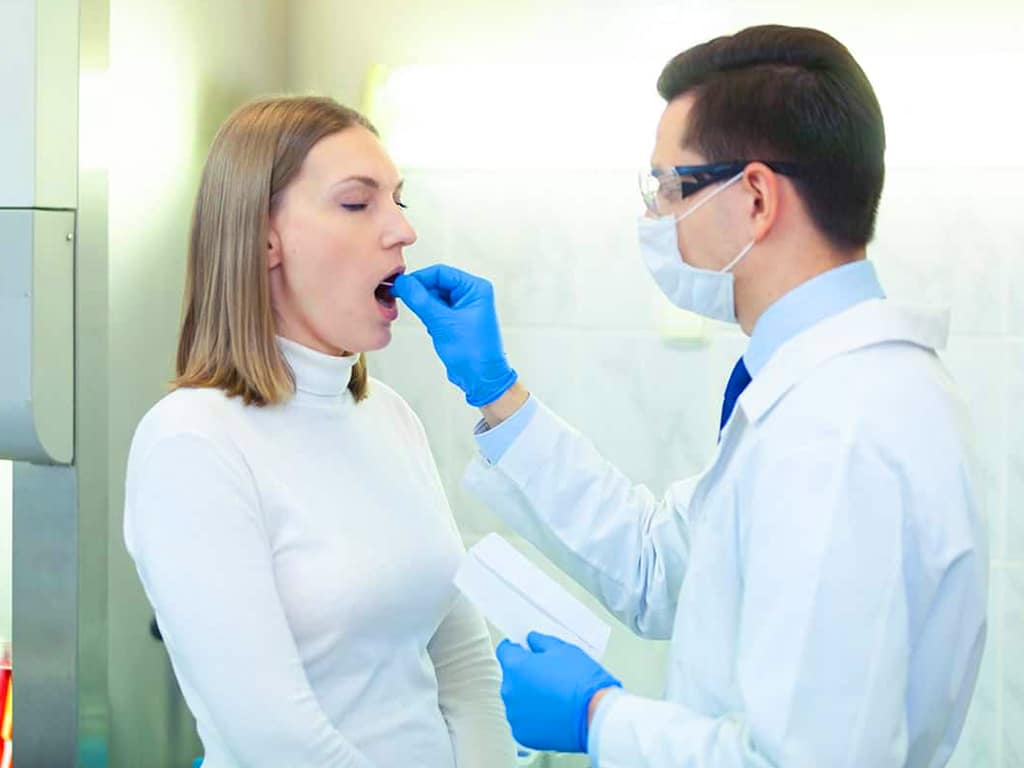 A medical professional conducting a saliva test