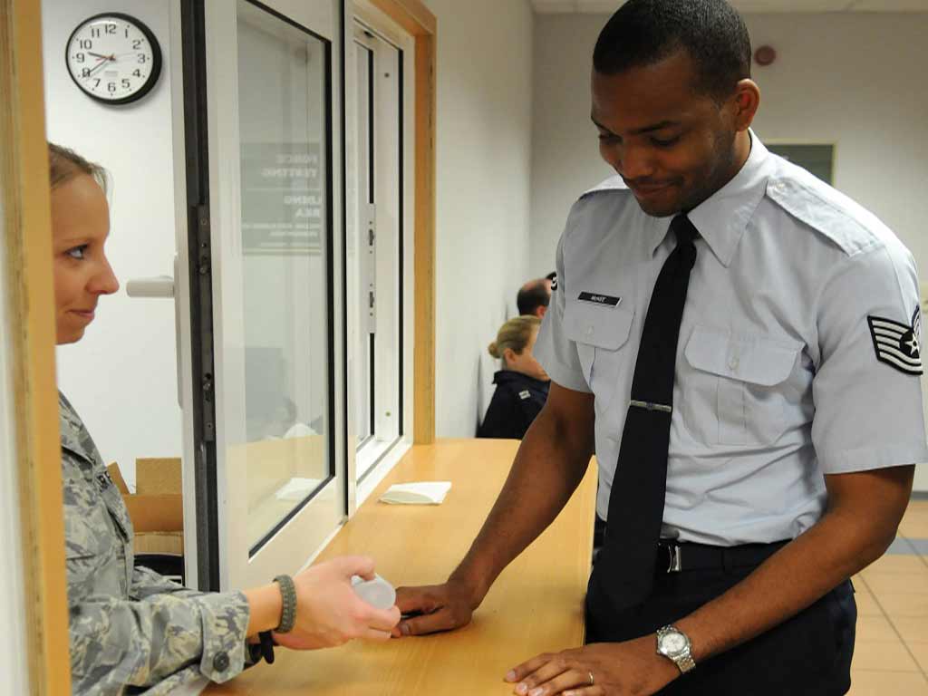 A uniformed officer giving a urine sample container for drug testing