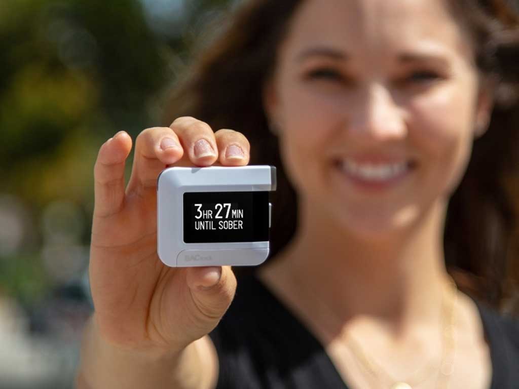 A woman using a BACTrack breathalyzer