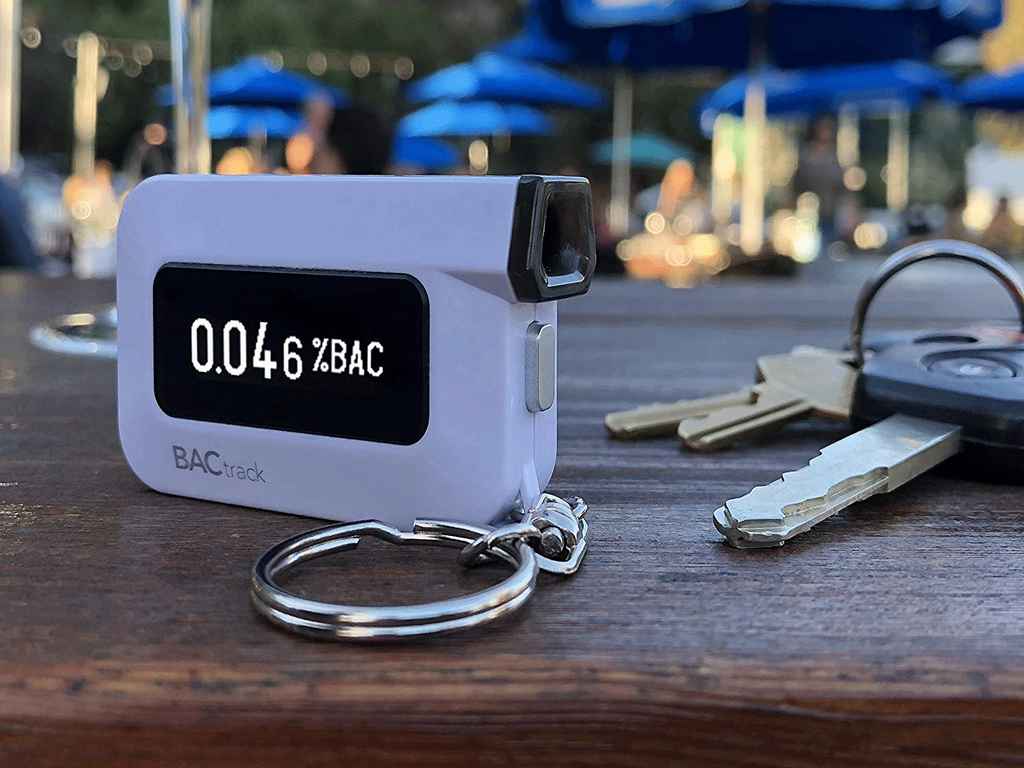 A keychain breathalyzer and keys on top of a table