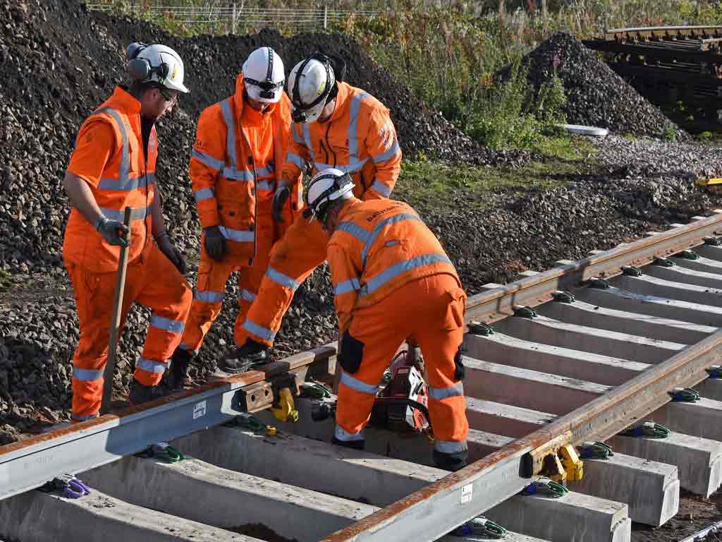 Construction workers building railway tracks.