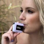 A woman blowing in a BACTrack breathalyzer