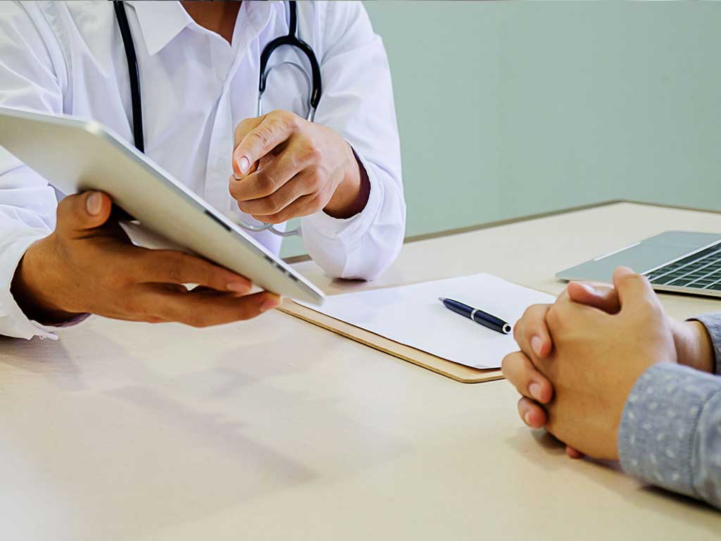 A doctor discussing medical information on a tablet device with a patient