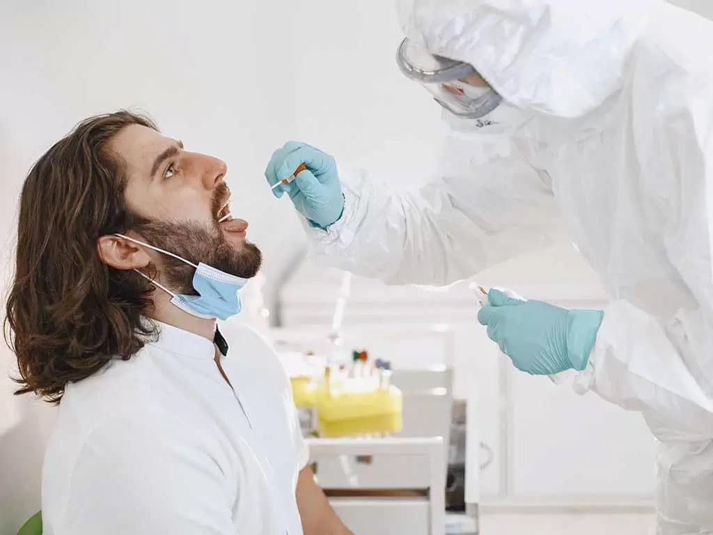 A man getting swabbed by a lab professional