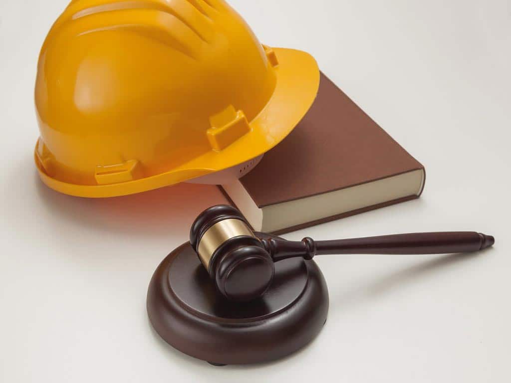 A hard hat on a book and a gavel