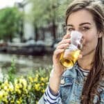 A woman drinking beer outdoors